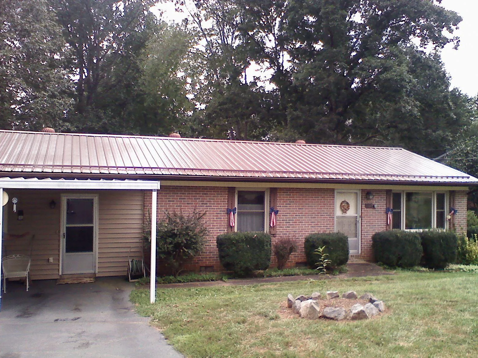 Bronze metal roof and carport on a brick ranch home — Roof Repair work by our crew in Duck River