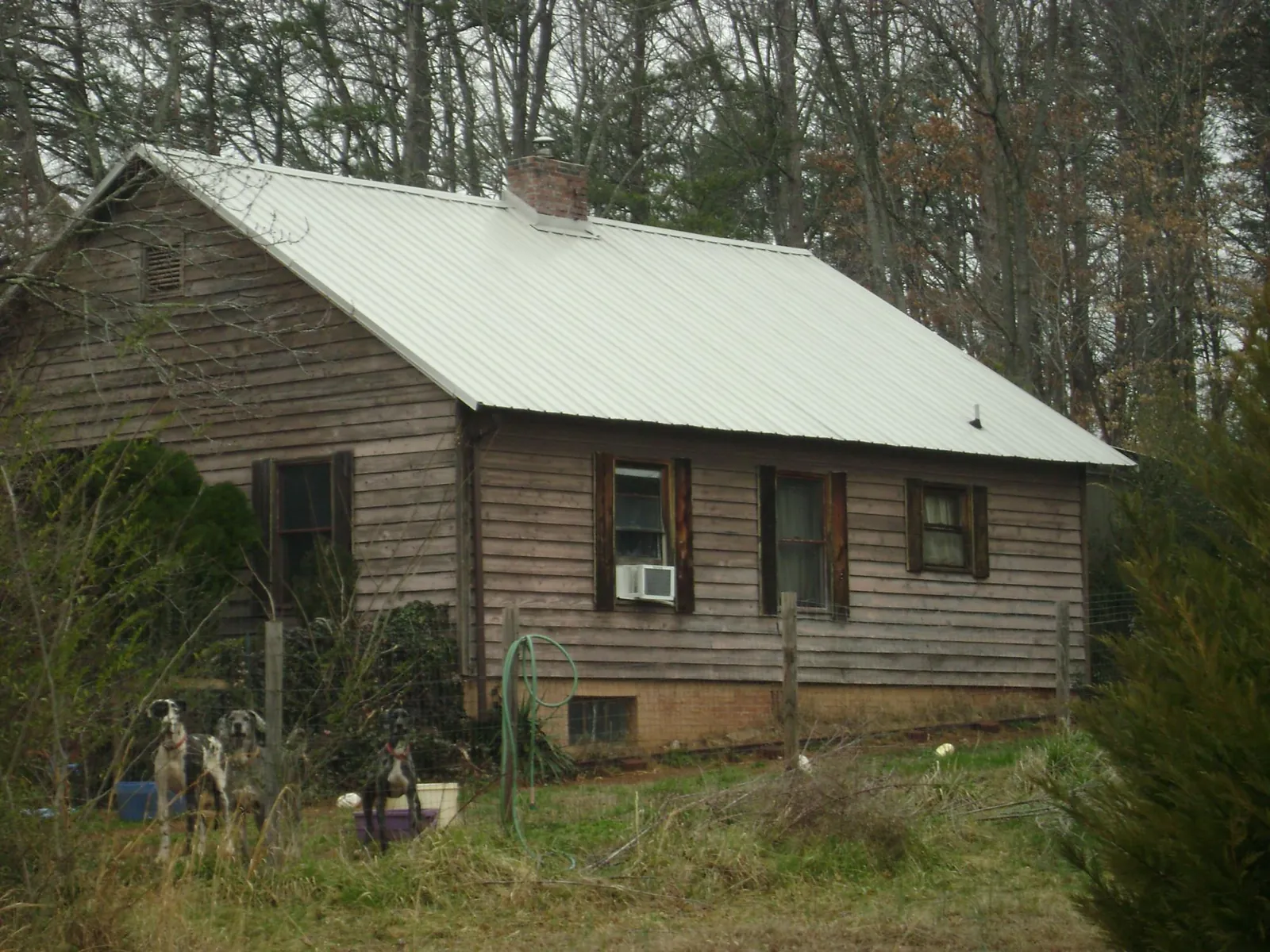 White metal roof on an old wood sided farmhouse, from a Metal Roof Installation job in Duck River
